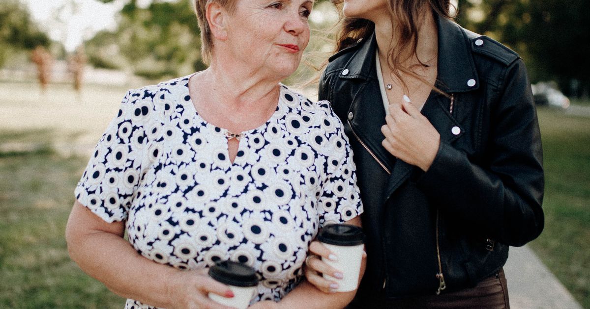 An older mother and her adult daughter share a warm, relaxed moment together at home