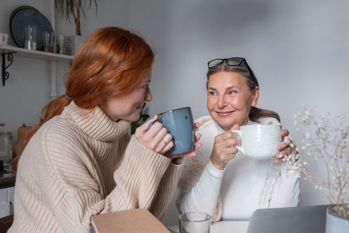 A mother and adult daughter chat over coffee, an easy daily ritual to anchor a new habit to