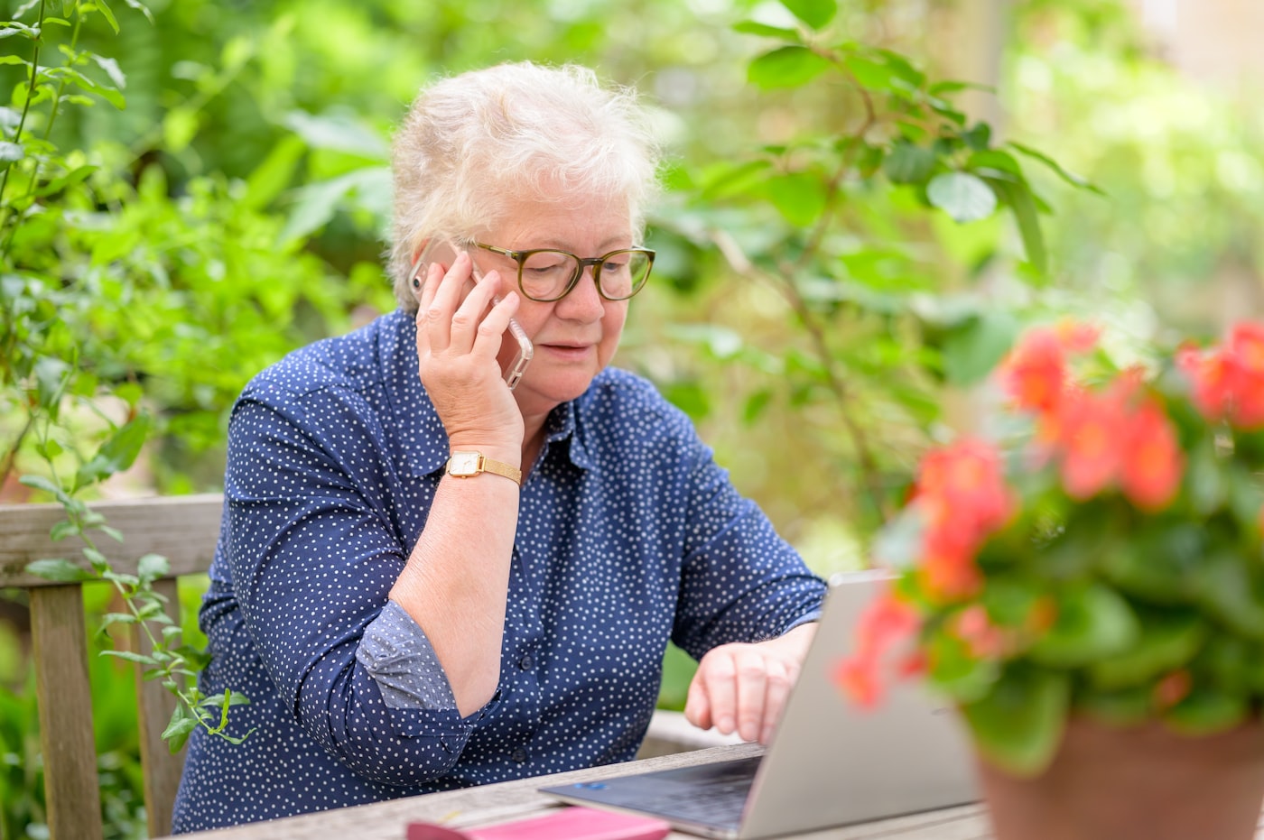 An older woman stays comfortably and independently connected at home with her laptop